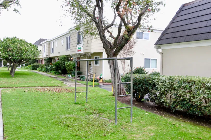 Large grassy front yard with monkey bars in the Chateau Blanc community.