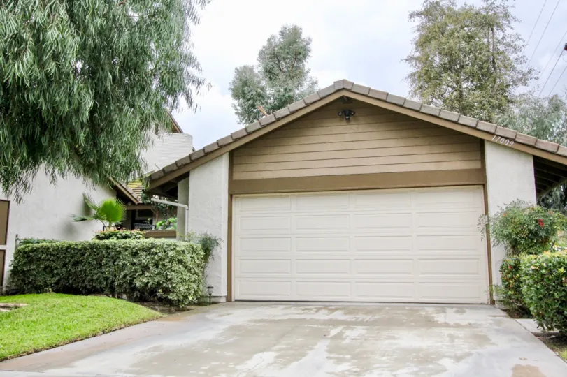 Cement driveway leading to a tan, cream and brown garage in the Emerald Glen community.