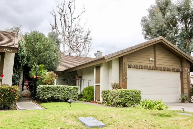 A cream and brown house with a garage decorated is located within the Emerald Glen community.
