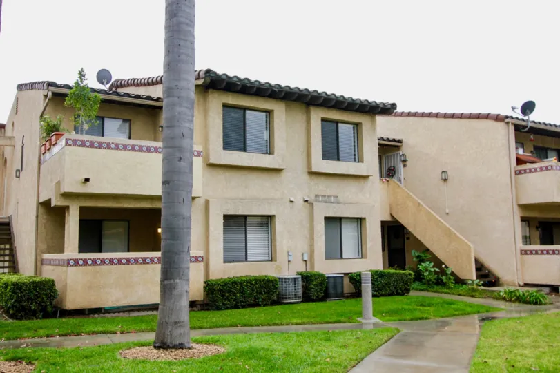 The beautiful houses in the Fountain Crest with beautiful ornamental plants and green grass near the foot path.