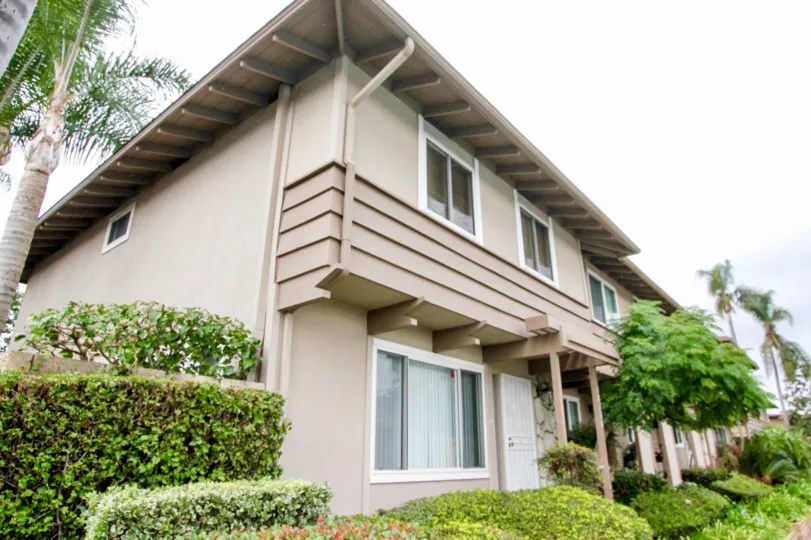 A tan residential building corner view with big windows and great landscaping located in the Fountain Plaza community.