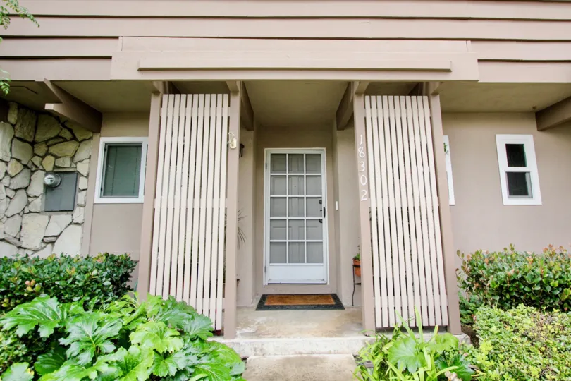 A white door as an entrance with the number 18302 listed in Fountain Plaza community.
