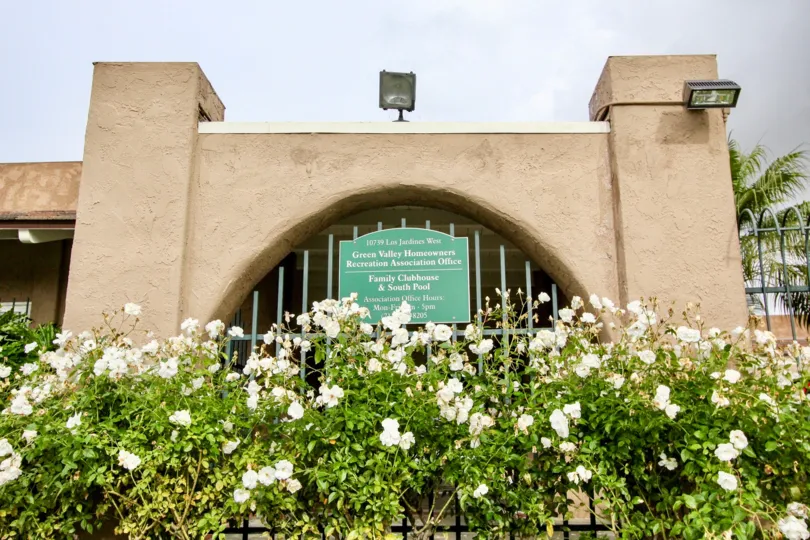 White flowers in front of the gate at Green Valley Townhomes Fountain Valley, CA
