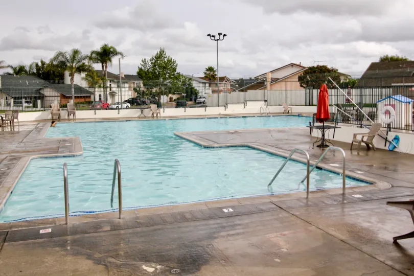 Near the swimming pool, umbrella is closed at dinning table in Green Valley Townhomes