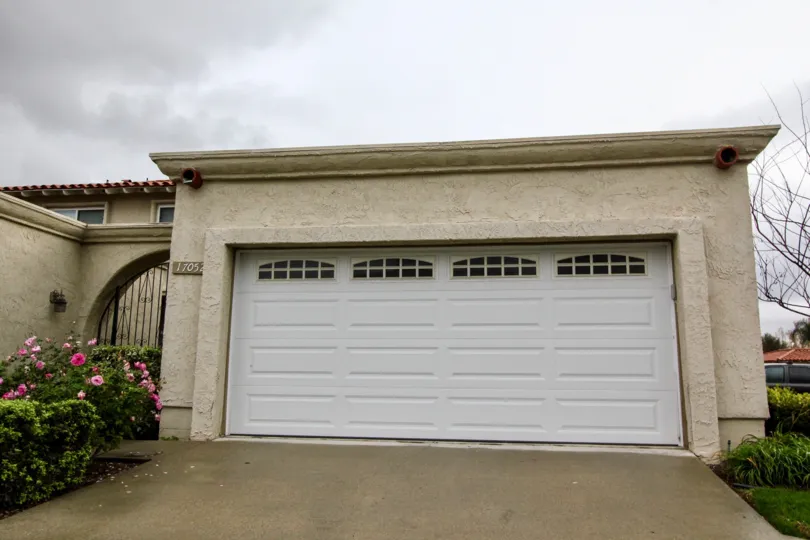 Front to the gate has flowers on bushes with car shed in Green Valley Warner Village