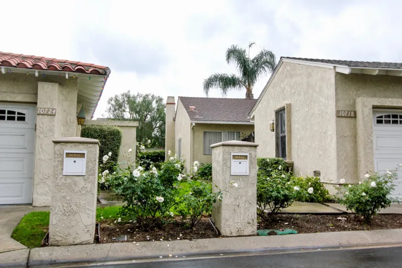 Tan residential homes with clay colored roofing with beautiful lanscaping in the Green Valley Warner Village community.