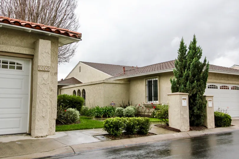 side of 10706 villa in Green Valley Warner Village has lawn with bushes and trees