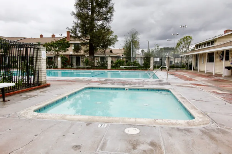 A long rectangle pool sits next to a square hot tub at Harbor Valley in Fountain Valley CA