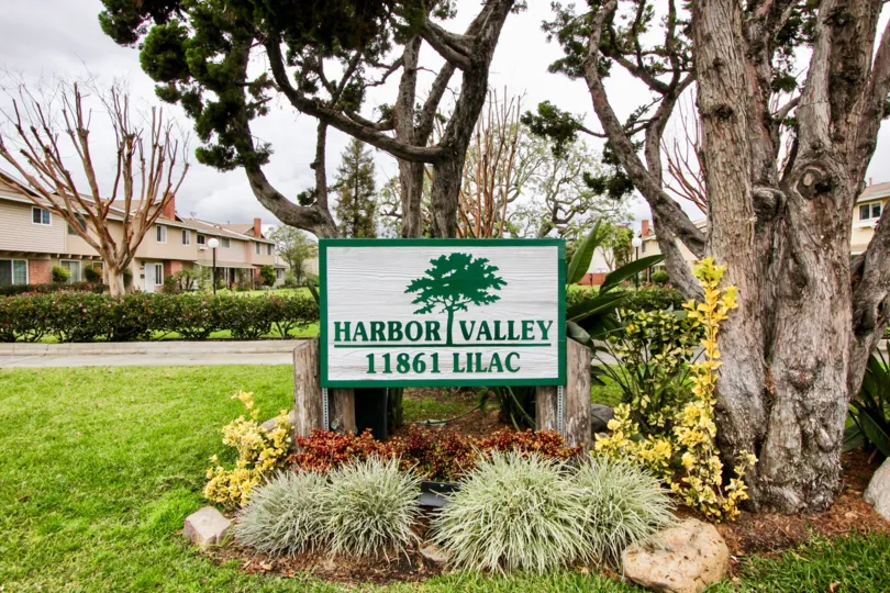 Entrance sign to community in white and green in color saying Harbor Valley.