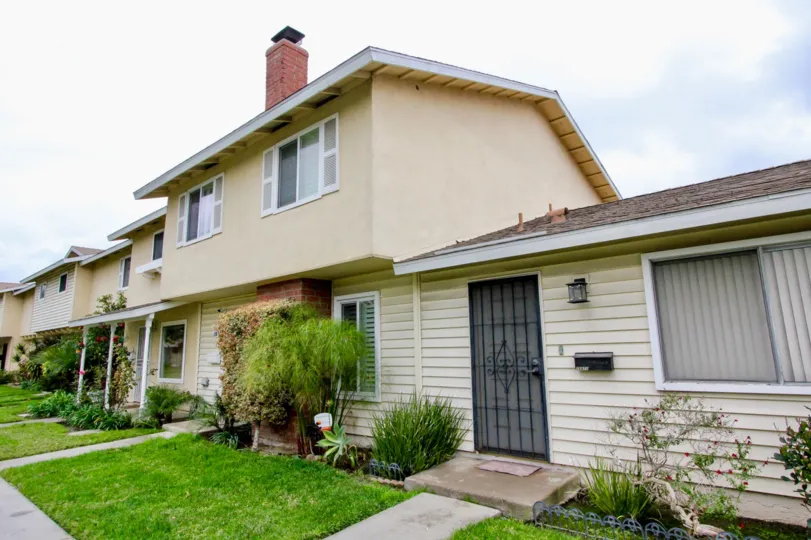 Long strip of modern housing with front yard in Harbor Valley community.