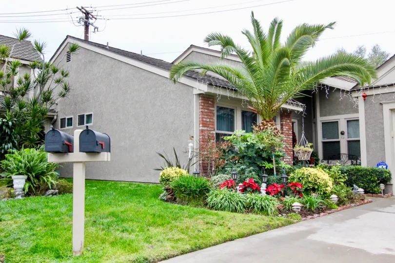 Two postal boxes are placed between the lawn with flowers and plants in Kingsbriar community