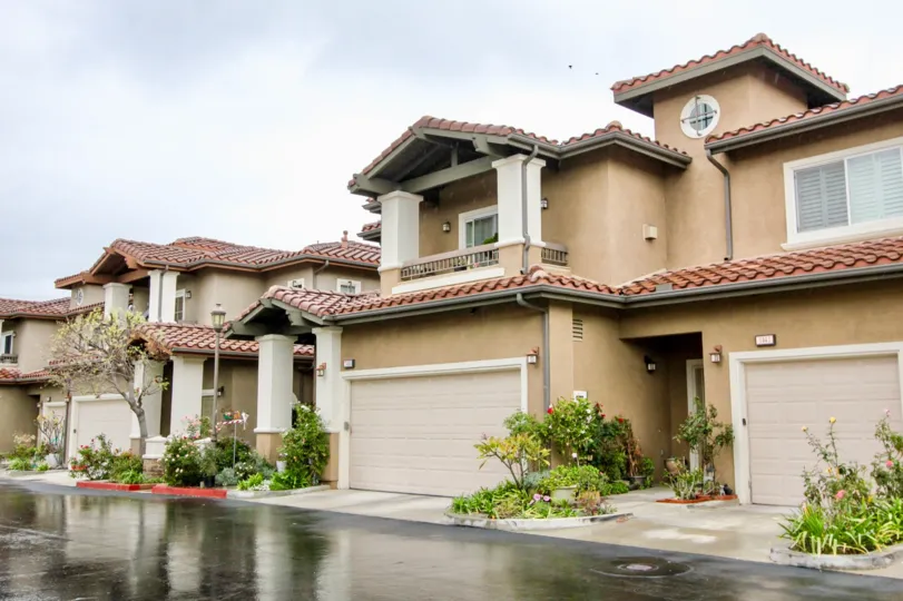 Residential area with porches, garages, and is tan in color located in Liberty Founder of Village community.
