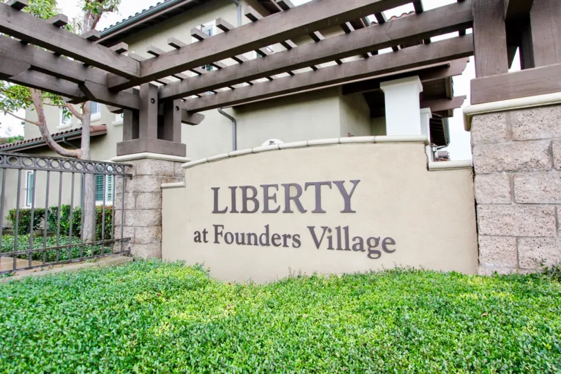 front to wall of Liberty Founder of Village has full of bushes with cutting bushes