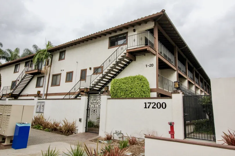 A large triple story housing building with two sets of stairs at Los Caballeros in Fountain Valley CA