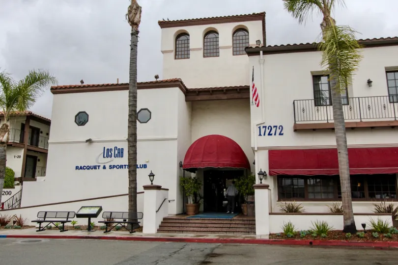 A sign in front of the building Los Cab Racquet & sportsclub located in the community Los Caballeros.