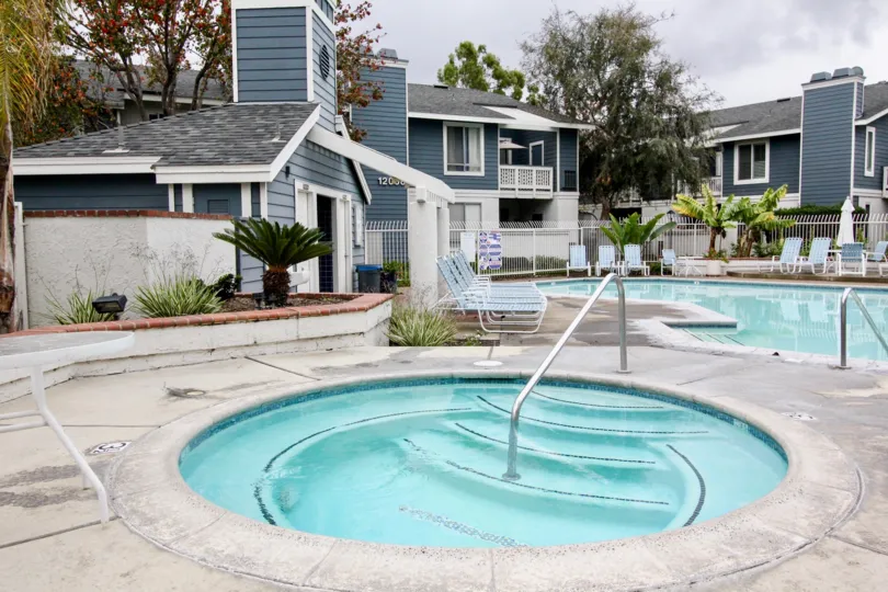 There are two swimming pools near New chase Villa's with seating chairs and trees