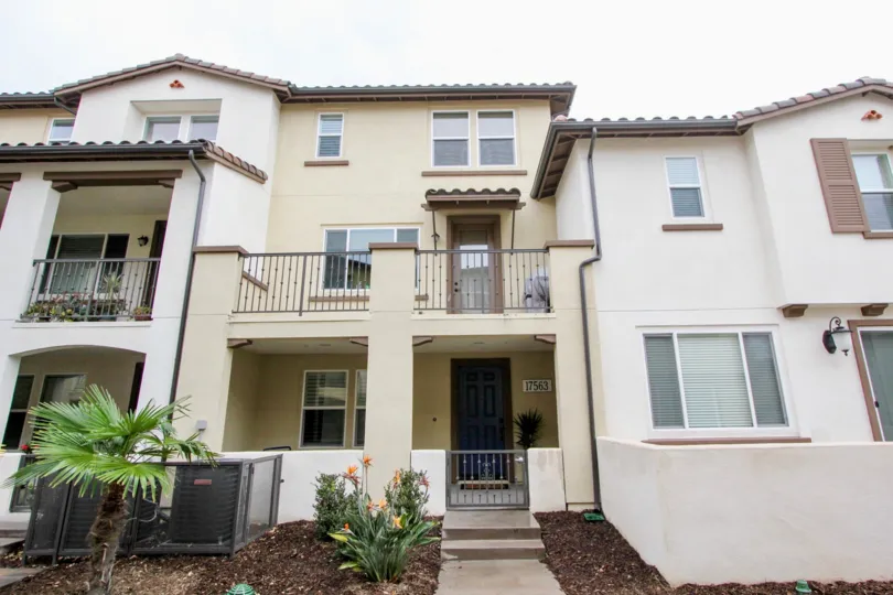 Multi level residential homes with balconies and porches with plants in front located in Solana Walk community.