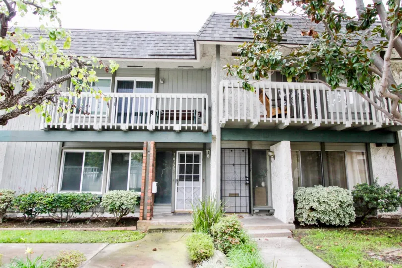 Seating bench is placed in balcony of the house in Tiburon North with bushes and trees