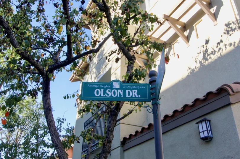 A green sign that says olson dr. with a building beside it in amerige heights community in fullerton, california.