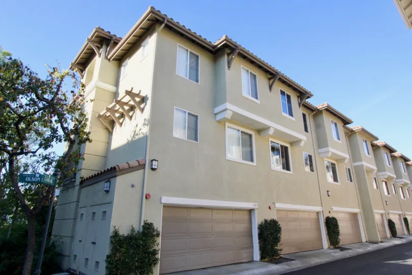 A beautiful apartment in the Amerige Heights with glass windows, big trees and ornamental plants near the road side.