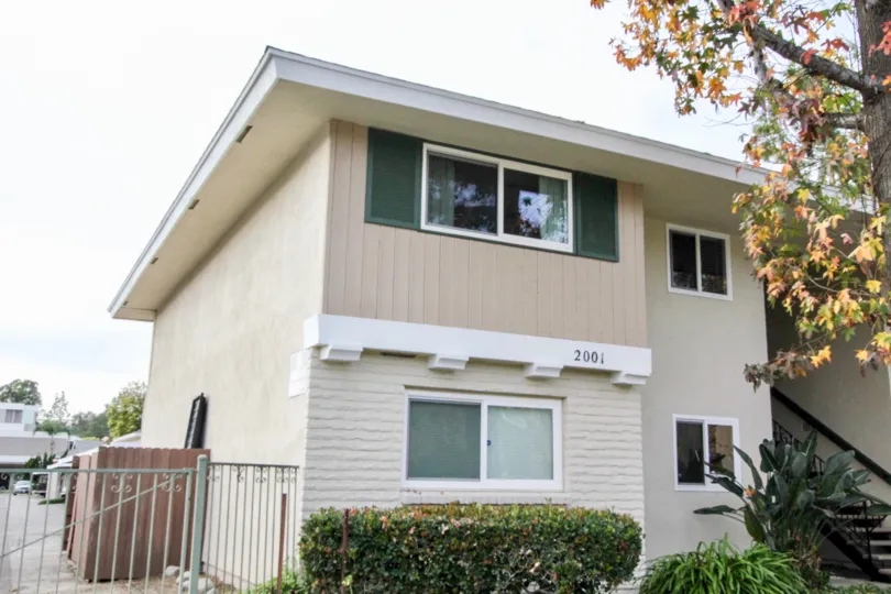 A two story apartment building in Casa Del Amo with a metal fence.