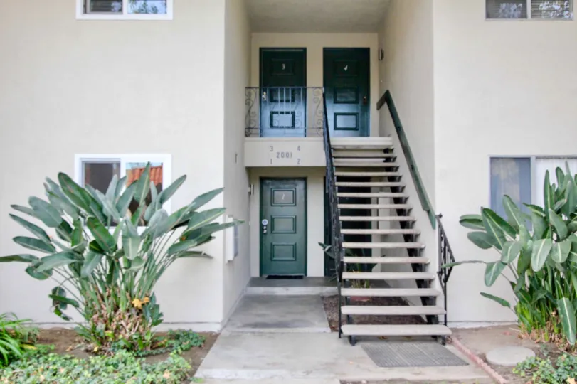 A staircase for a two story building in Casa Del Amo with plant on either side.