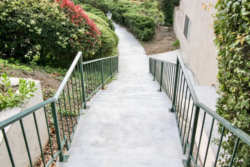 A staircase in Casa Del Vista with bushes on either side.