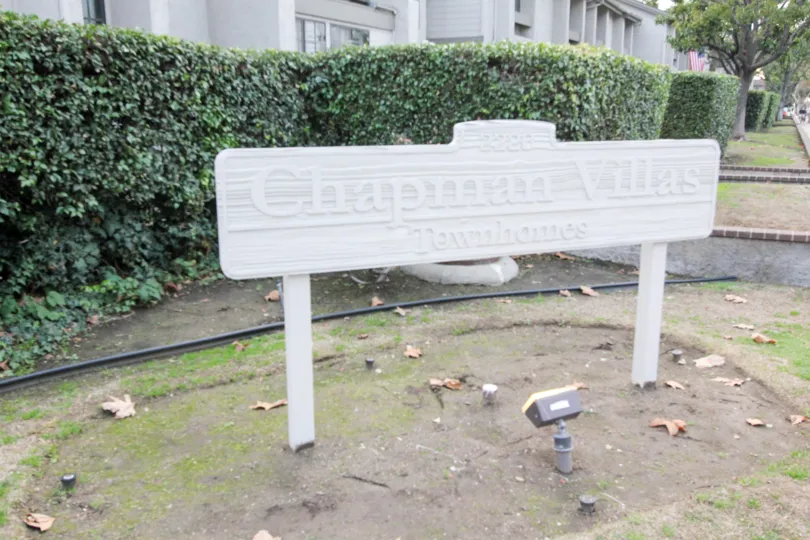 A day in the Chapman Villas with a sign board and plant.