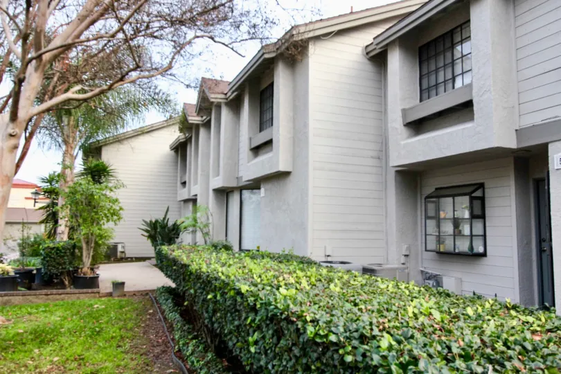 white townhomes with bushes in the front in chapman villas community in fullerton, california.