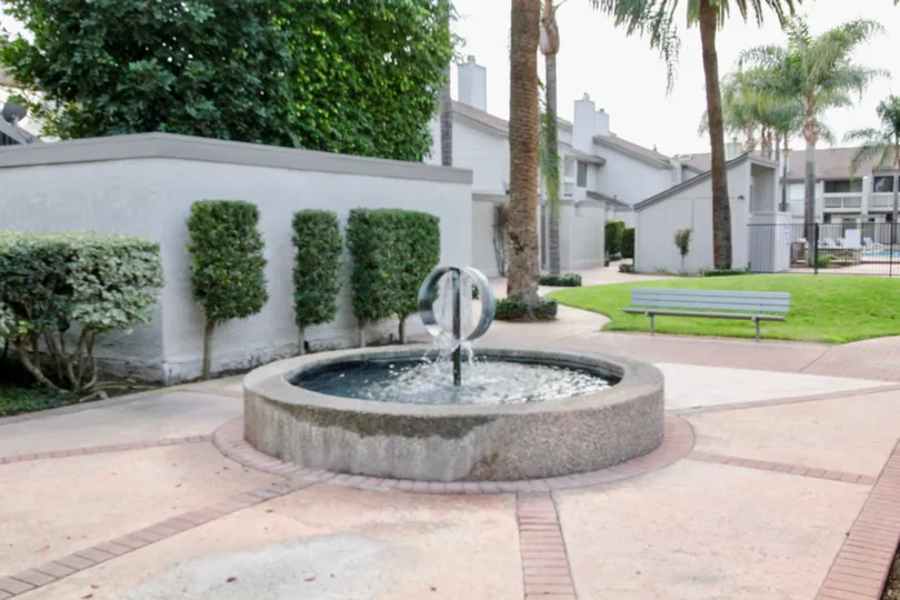 In pathway, Fountain with water and bench are fixed at center in Chapman Villas