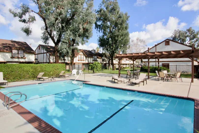 A sunny day for the pool in Chelsea Park Estates with deck chairs and tables.