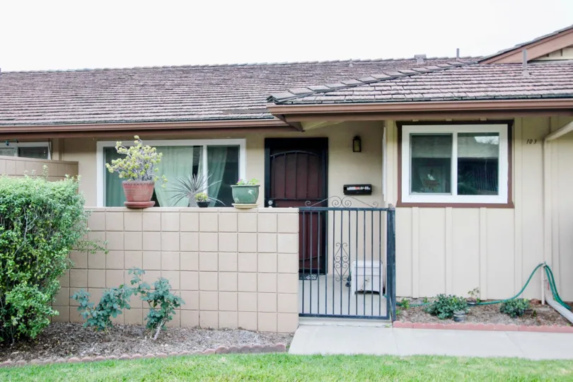 A single story home with a black iron gate near it's front door at coco Palms in Fullerton CA
