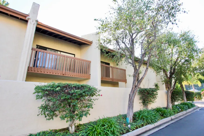 A apartment building in Country Villas with a balcony and trees.