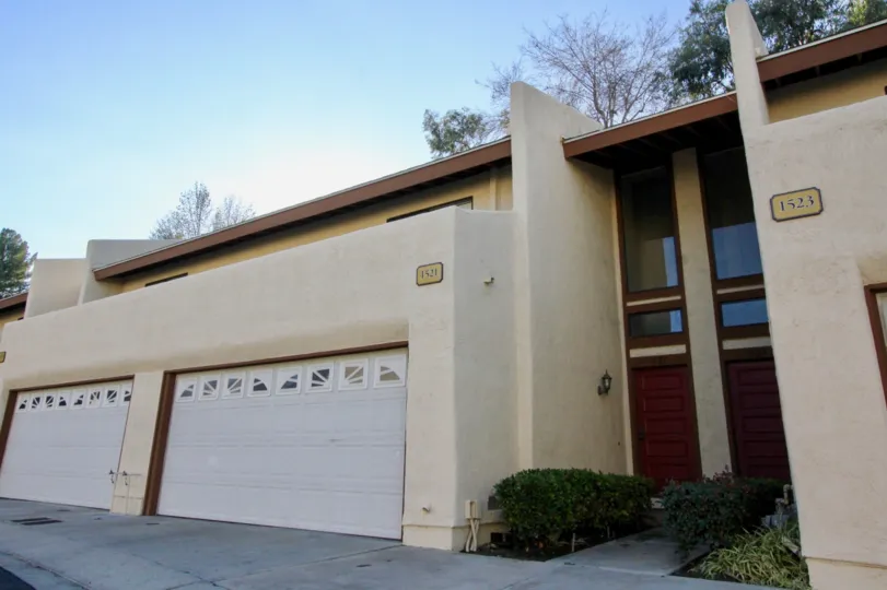 A apartment building in Country Villas with two garages on a sunny day.
