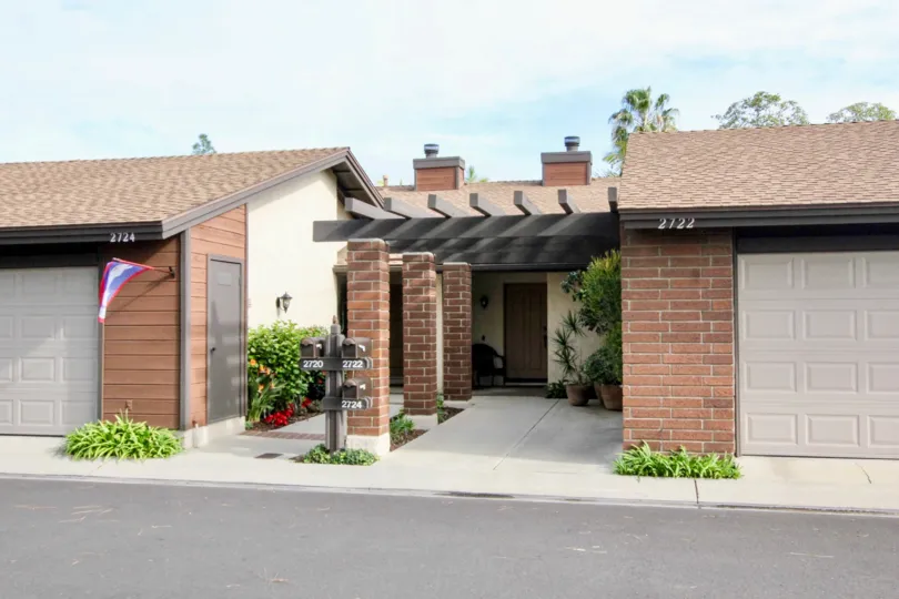 A homes in Fullerton Pines with garages and flags on a sunny day.