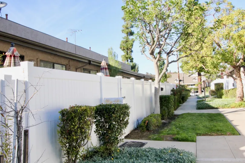 Inside the compound wall of villa in Gilbert Vista has few closed umbrella with tall trees and cutting bushes
