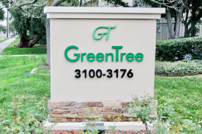 A cement welcome sign with brick base in Green Tree Fullerton, CA