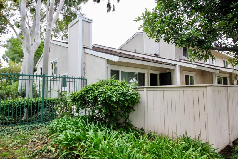 A wooden and metal fence in the Green Tree community by a home.
