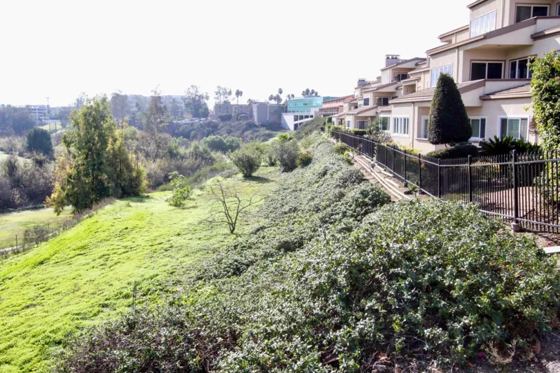 The hilly area in the Greenview Terrace with full of green grass, shrubs, ornamental plants near the beautiful buildings.