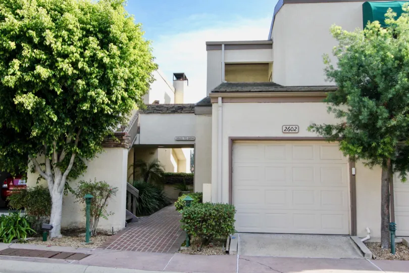 A two story apartment building in Greenview Terrace with a garage and trees on either side.