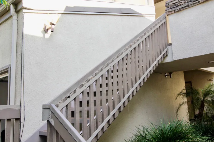 A staircase in Greenview Terrace with a palm tree and lamp.