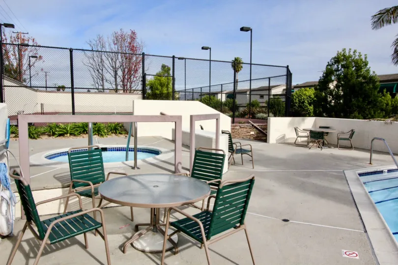 Hot spa and pool with patio tables and chairs at Greenview Terrace.
