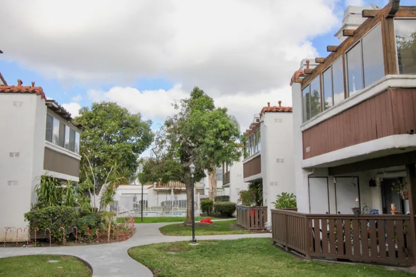 A path between apartments in the Heritage Fullerton community with trees and candy canes.