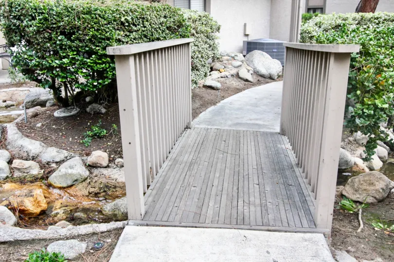 A bridge in the Hidden Lakes community with a stream below it.