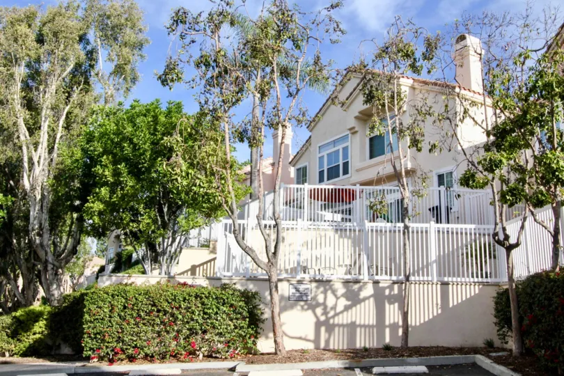 A tall and bright condo building with stairs and railings at Maison De Fleur in Fullerton CA