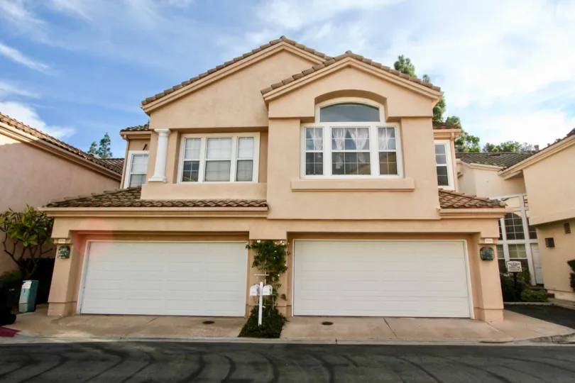A duplex in Maison de Fleur with garages and a terra cotta roof.