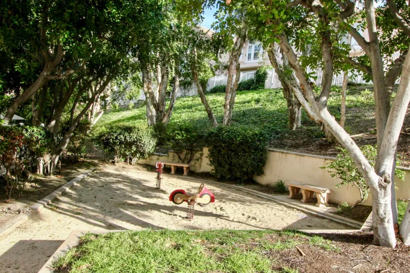 Beyond the villa in Maison de fleur has sand with seating benches, trees and grasses