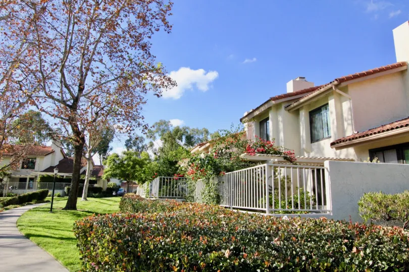 The big house with front gate and it looking beautiful white color and a small garden available at the front gate of the house in morning sunshine time.