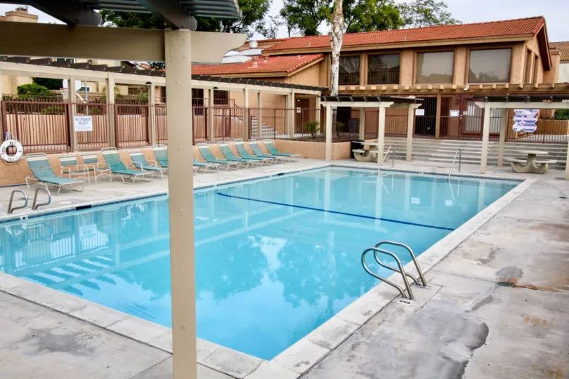 Mark III Townhomes Fullerton California brown colored buildings and blue color pool, chairs looks good
