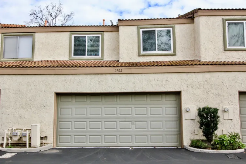 A Mark III Townhomes building with a garage and square windows on a cloudy day.